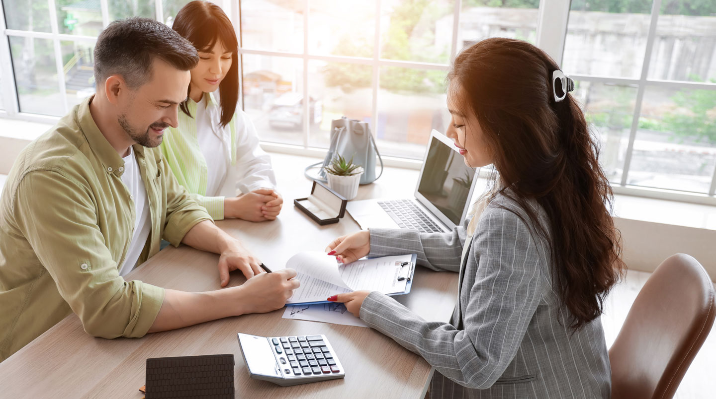 Mains professionnelles signant des documents immobiliers sur un bureau de notaire contemporain